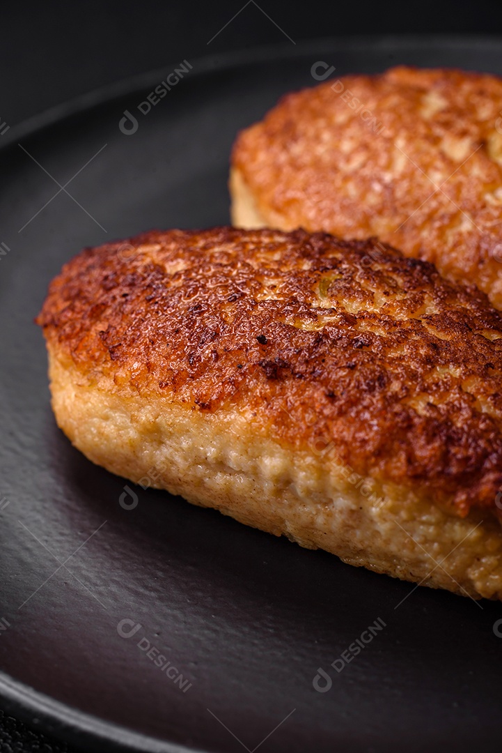 Deliciosas costeletas fritas ou almôndegas de peixe picado com especiarias e ervas sobre um fundo escuro de concreto