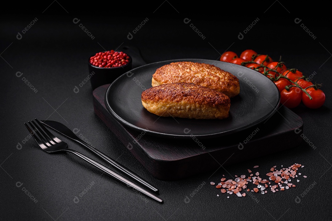 Deliciosas costeletas fritas ou almôndegas de peixe picado com especiarias e ervas sobre um fundo escuro de concreto