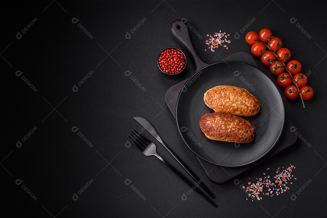 Deliciosas costeletas fritas ou almôndegas de peixe picado com especiarias e ervas sobre um fundo escuro de concreto