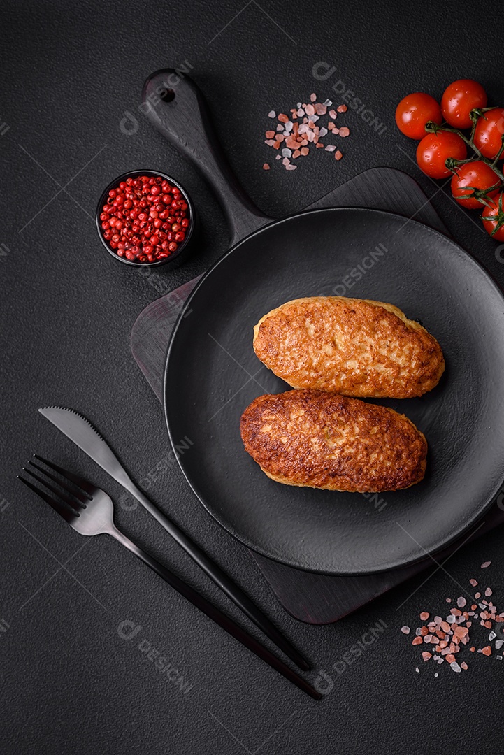 Deliciosas costeletas fritas ou almôndegas de peixe picado com especiarias e ervas sobre um fundo escuro de concreto