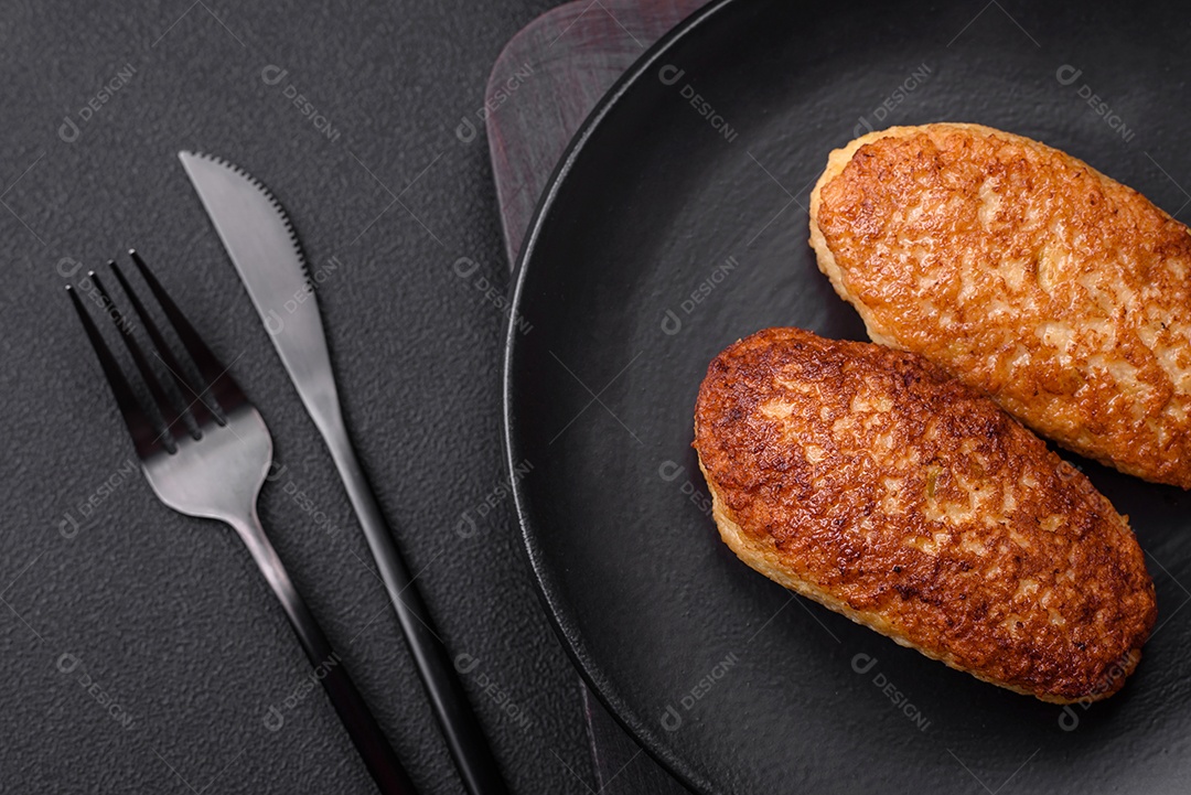 Deliciosas costeletas fritas ou almôndegas de peixe picado com especiarias e ervas sobre um fundo escuro de concreto
