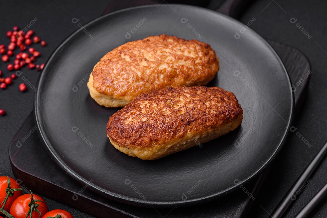 Deliciosas costeletas fritas ou almôndegas de peixe picado com especiarias e ervas sobre um fundo escuro de concreto