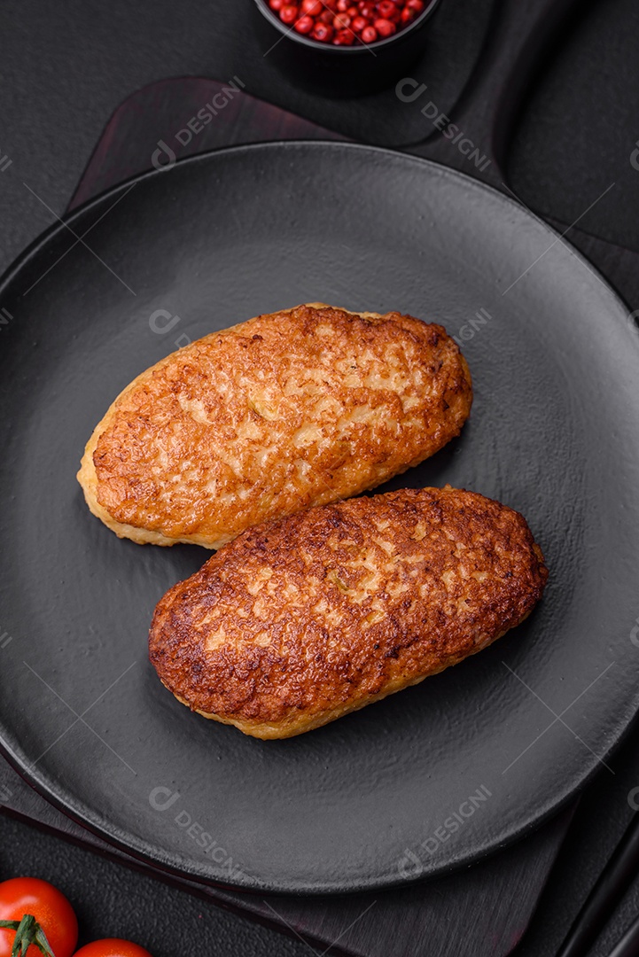 Deliciosas costeletas fritas ou almôndegas de peixe picado com especiarias e ervas sobre um fundo escuro de concreto