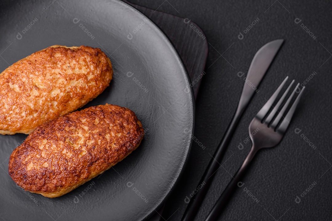 Deliciosas costeletas fritas ou almôndegas de peixe picado com especiarias e ervas sobre um fundo escuro de concreto