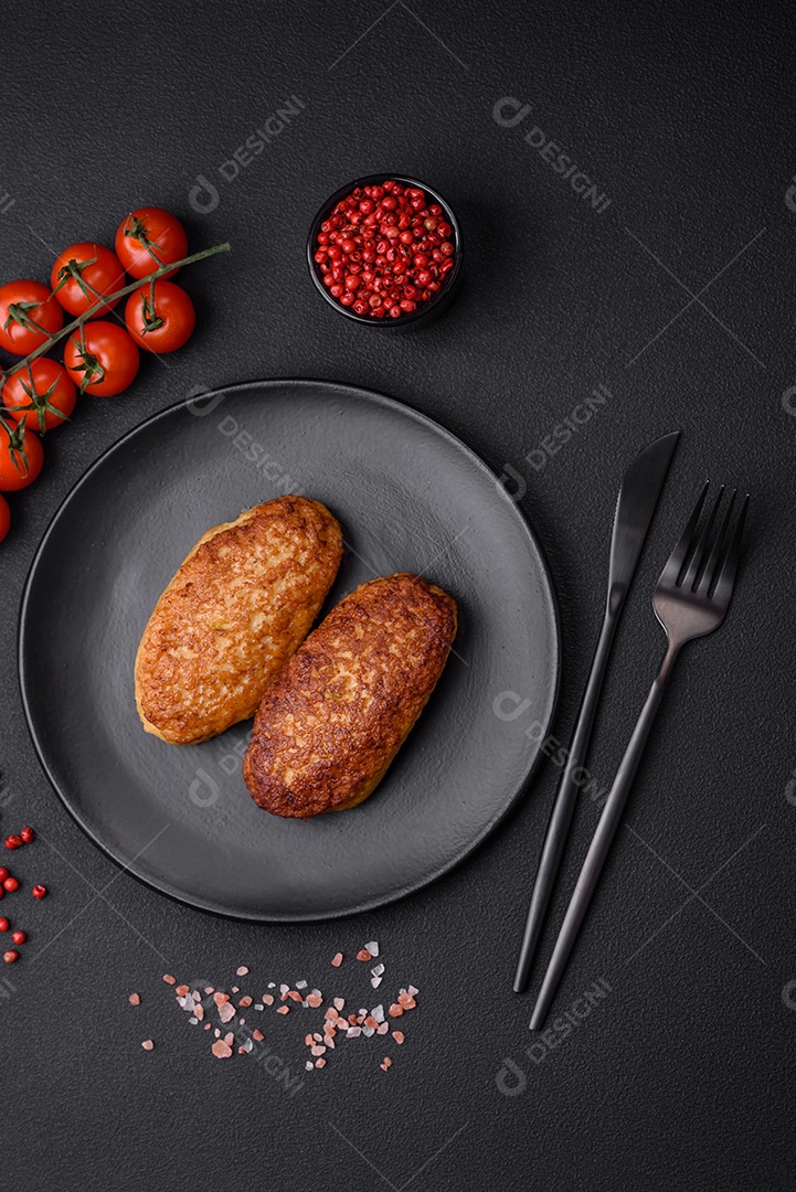 Deliciosas costeletas fritas ou almôndegas de peixe picado com especiarias e ervas sobre um fundo escuro de concreto