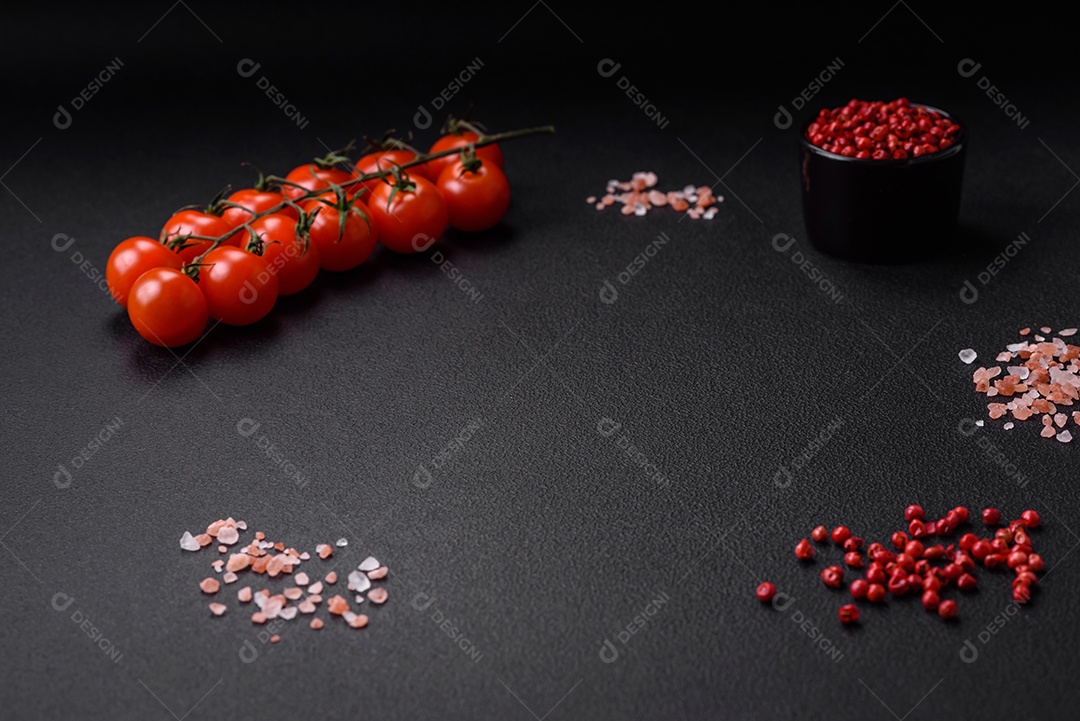 Deliciosos tomates cereja frescos em um galho em um fundo escuro de concreto. Cozinha vegetariana