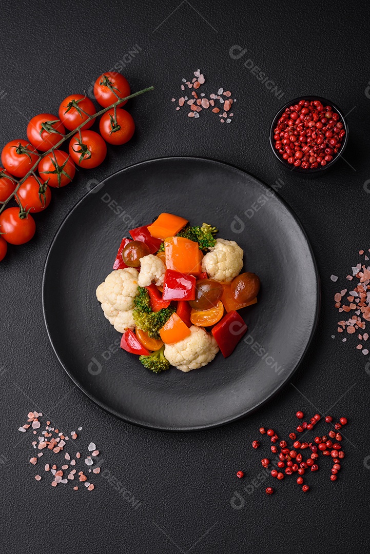 Delicioso prato composto por pedaços de frango cozido, brócolis e cenoura com especiarias e ervas sobre um fundo escuro de concreto