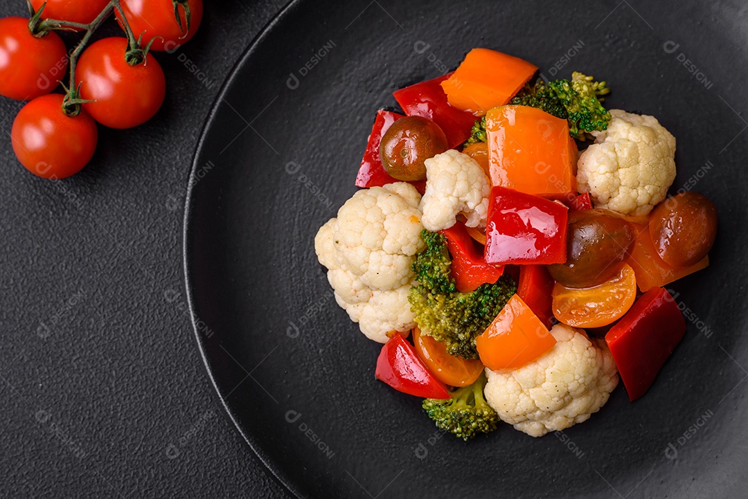 Delicioso prato composto por pedaços de frango cozido, brócolis e cenoura com especiarias e ervas sobre um fundo escuro de concreto