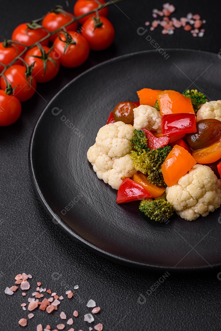 Delicioso prato composto por pedaços de frango cozido, brócolis e cenoura com especiarias e ervas sobre um fundo escuro de concreto