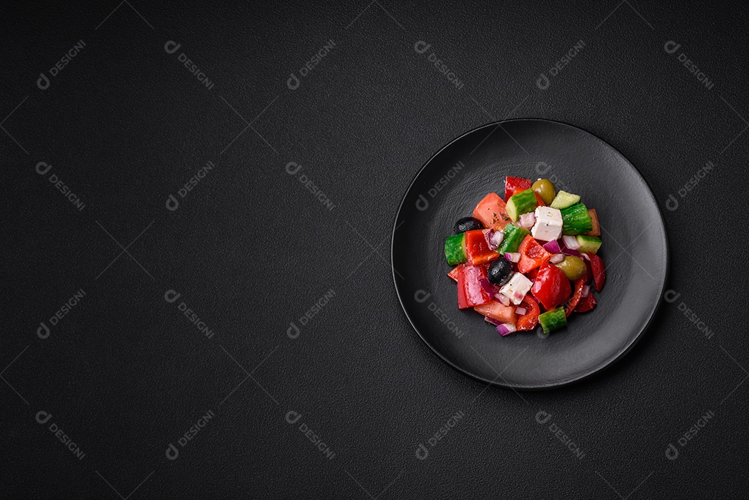 Salada grega deliciosa e fresca com queijo feta, azeitonas, tomates e pepinos sobre um fundo escuro de concreto