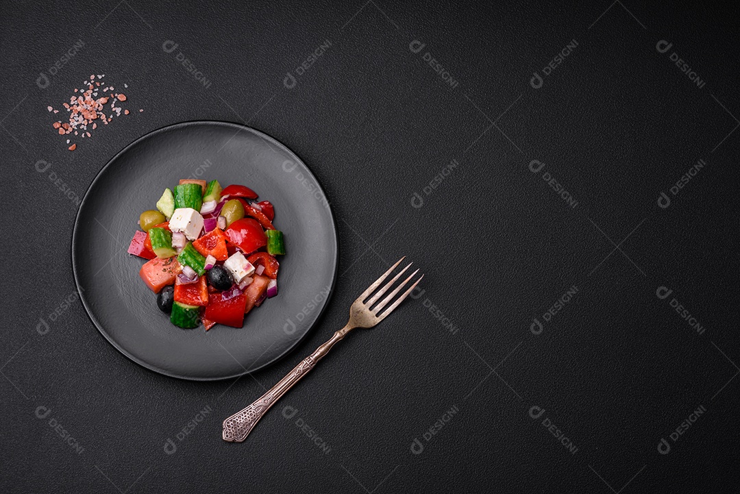Salada grega deliciosa e fresca com queijo feta, azeitonas, tomates e pepinos sobre um fundo escuro de concreto