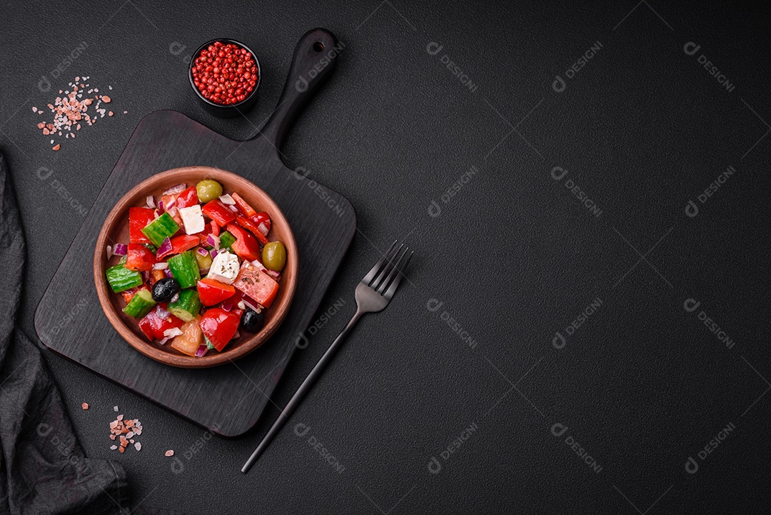 Salada grega deliciosa e fresca com queijo feta, azeitonas, tomates e pepinos sobre um fundo escuro de concreto