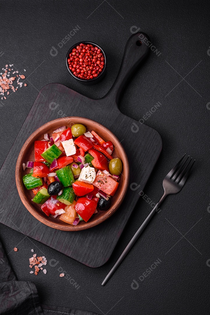 Salada grega deliciosa e fresca com queijo feta, azeitonas, tomates e pepinos sobre um fundo escuro de concreto