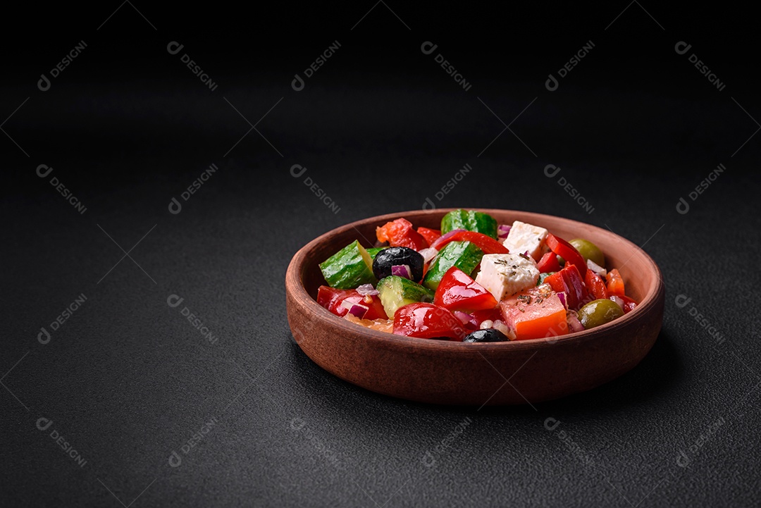 Salada grega deliciosa e fresca com queijo feta, azeitonas, tomates e pepinos sobre um fundo escuro de concreto