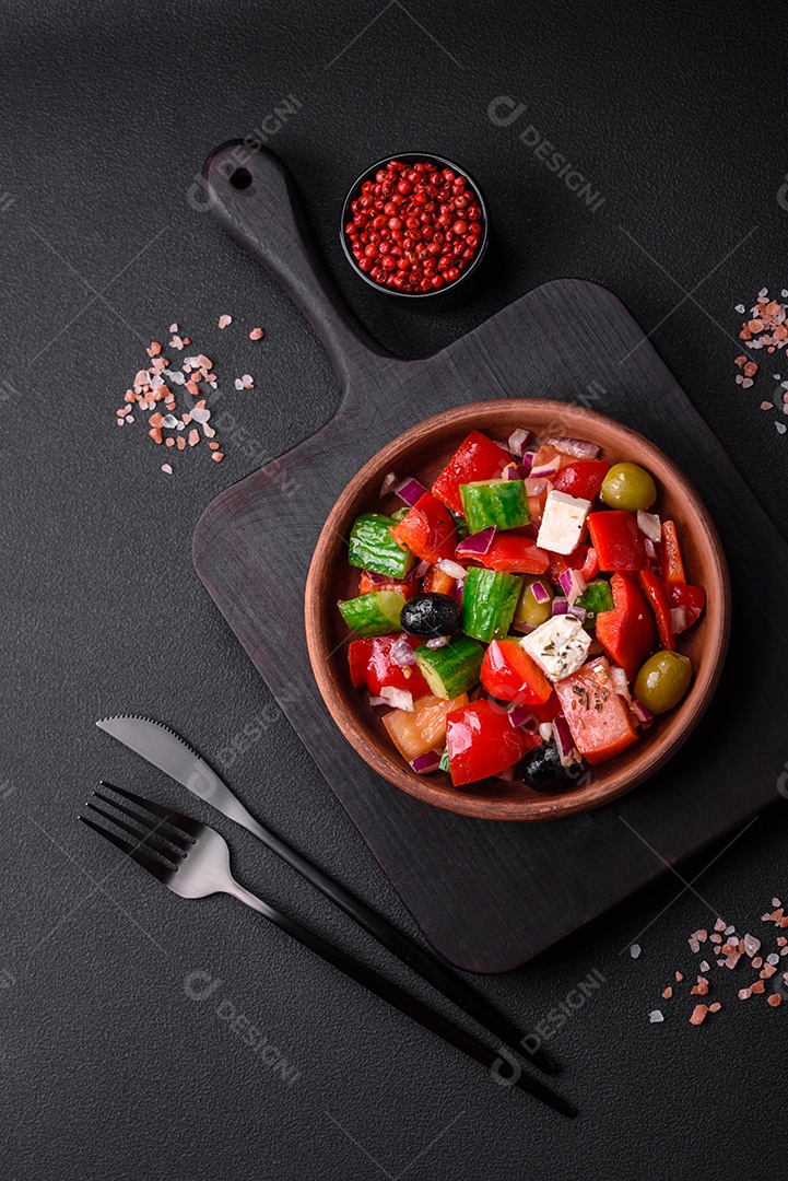 Salada grega deliciosa e fresca com queijo feta, azeitonas, tomates e pepinos sobre um fundo escuro de concreto