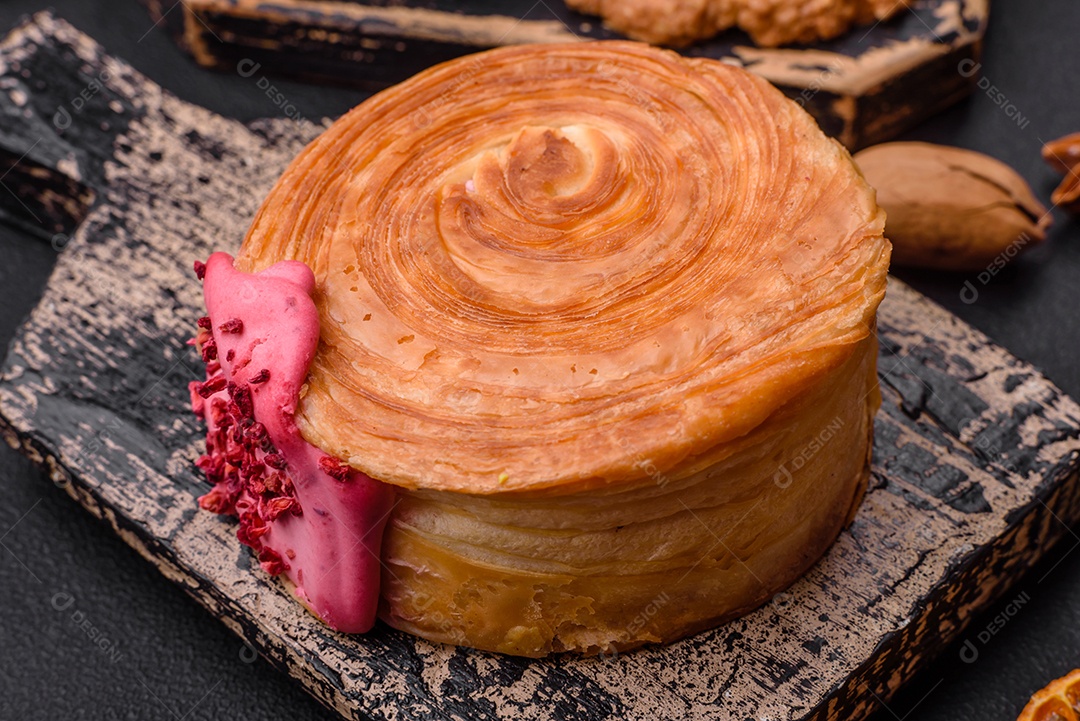 Croissant redondo de massa folhada com recheio de framboesa ou rolo de Nova Iorque sobre fundo escuro de concreto