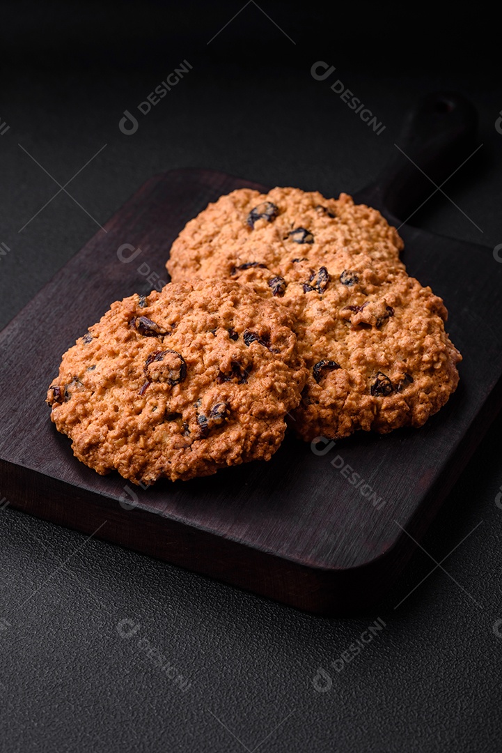 Deliciosos biscoitos de aveia assados ​​em um fundo escuro de concreto. Doces no café da manhã