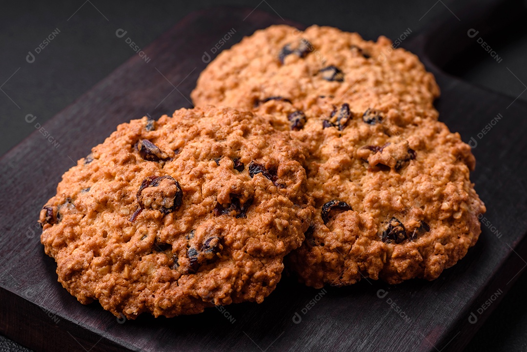 Deliciosos biscoitos de aveia assados ​​em um fundo escuro de concreto. Doces no café da manhã