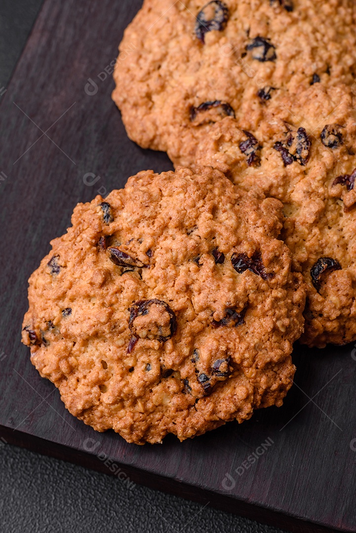 Deliciosos biscoitos de aveia assados ​​em um fundo escuro de concreto. Doces no café da manhã