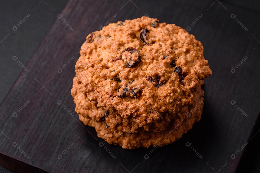 Deliciosos biscoitos de aveia assados ​​em um fundo escuro de concreto. Doces no café da manhã