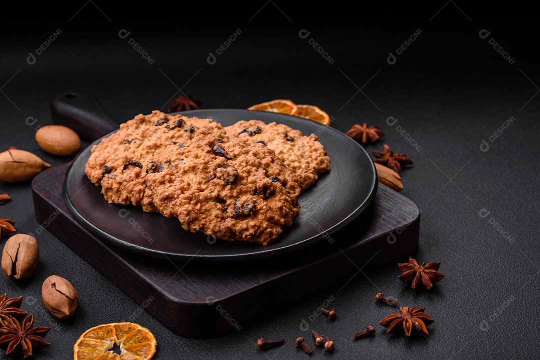 Deliciosos biscoitos de aveia assados ​​em um fundo escuro de concreto. Doces no café da manhã