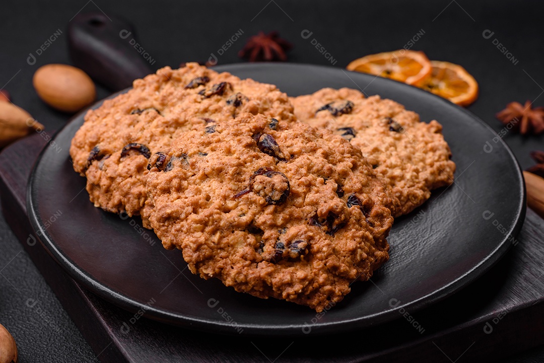 Deliciosos biscoitos de aveia assados ​​em um fundo escuro de concreto. Doces no café da manhã