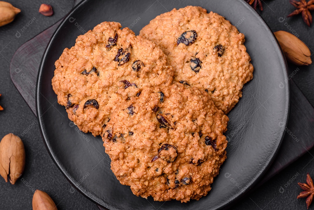 Deliciosos biscoitos de aveia assados ​​em um fundo escuro de concreto. Doces no café da manhã