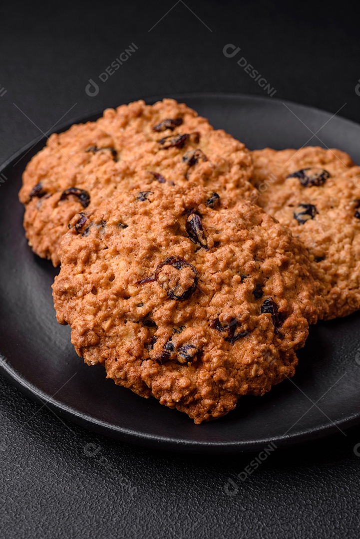 Deliciosos biscoitos de aveia assados ​​em um fundo escuro de concreto. Doces no café da manhã