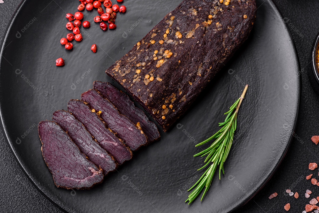 Delicioso basturma armênio defumado com especiarias e ervas cortadas em um fundo escuro de concreto