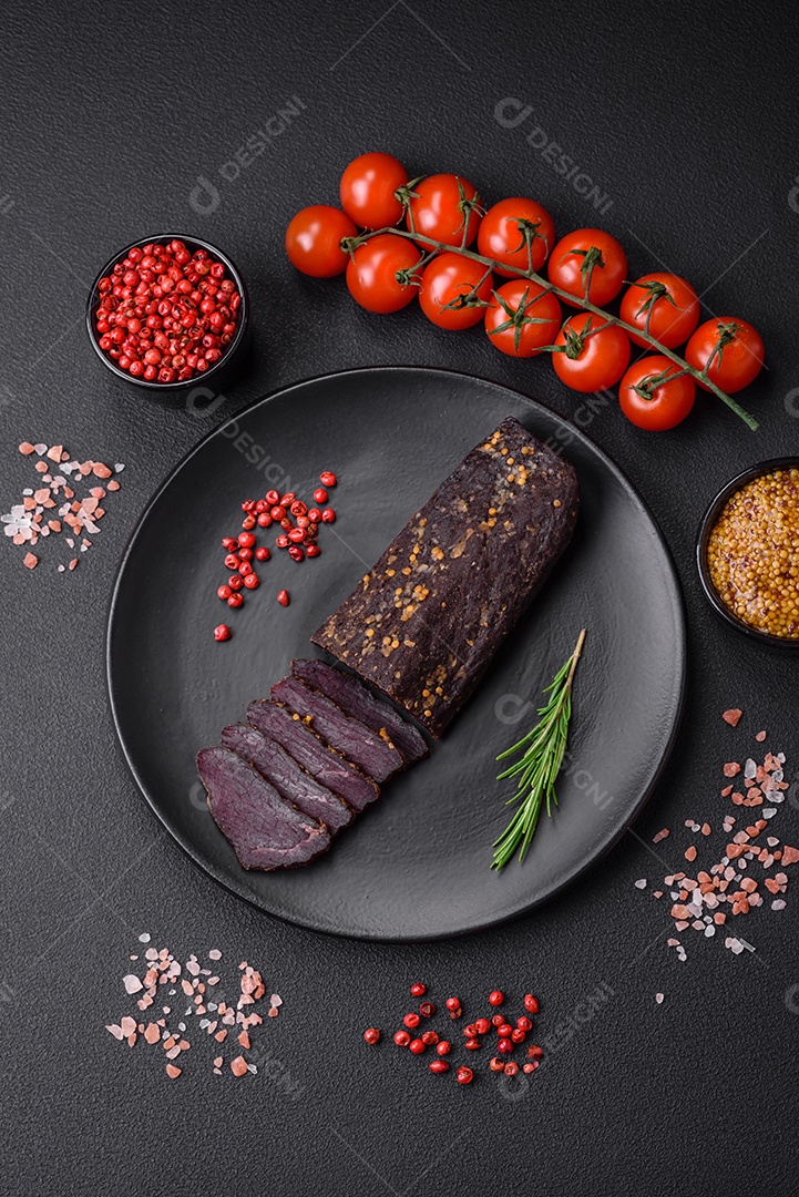 Delicioso basturma armênio defumado com especiarias e ervas cortadas em um fundo escuro de concreto