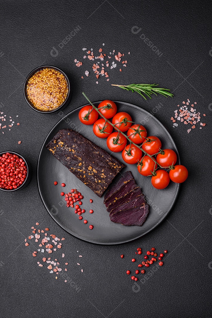 Delicioso basturma armênio defumado com especiarias e ervas cortadas em um fundo escuro de concreto