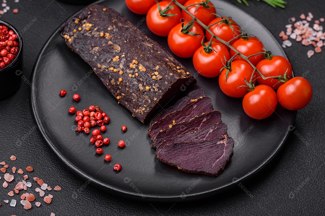 Delicioso basturma armênio defumado com especiarias e ervas cortadas em um fundo escuro de concreto