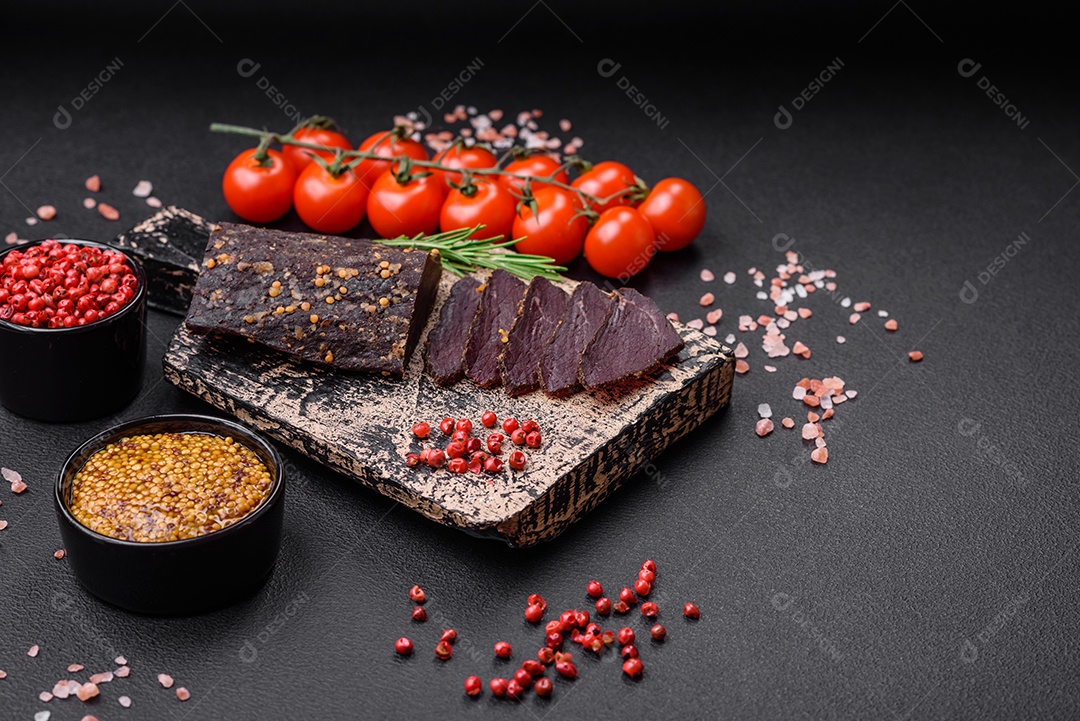 Delicioso basturma armênio defumado com especiarias e ervas cortadas em um fundo escuro de concreto