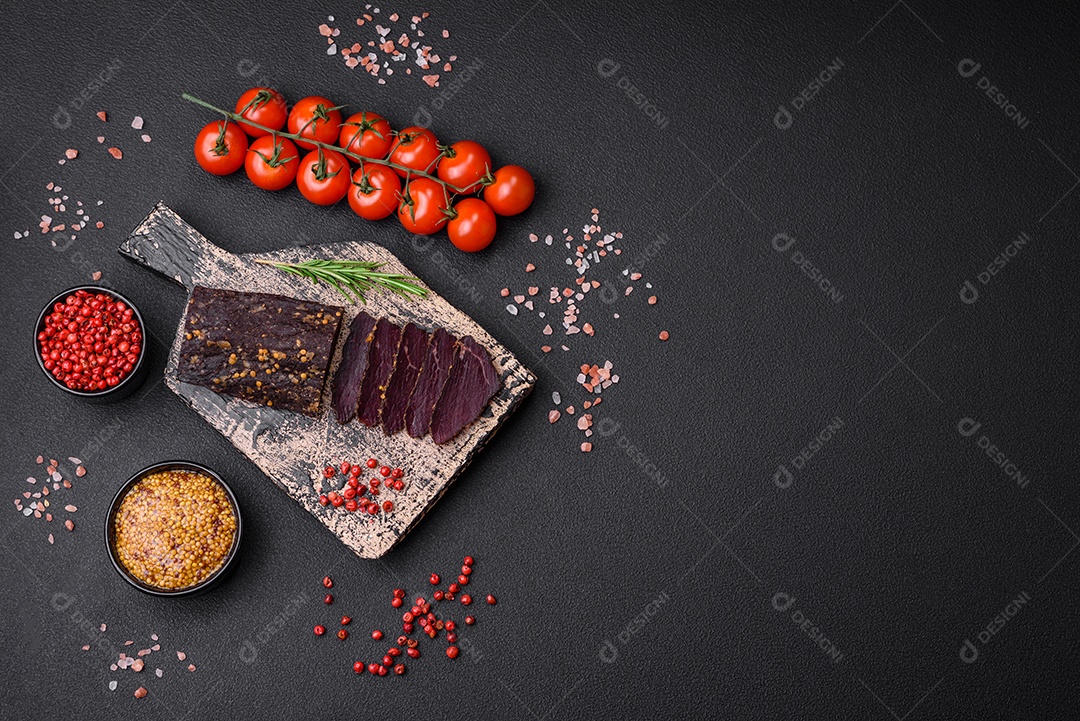 Delicioso basturma armênio defumado com especiarias e ervas cortadas em um fundo escuro de concreto