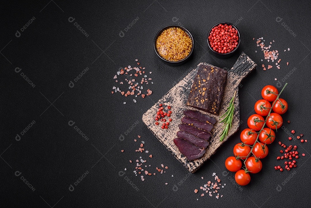 Delicioso basturma armênio defumado com especiarias e ervas cortadas em um fundo escuro de concreto