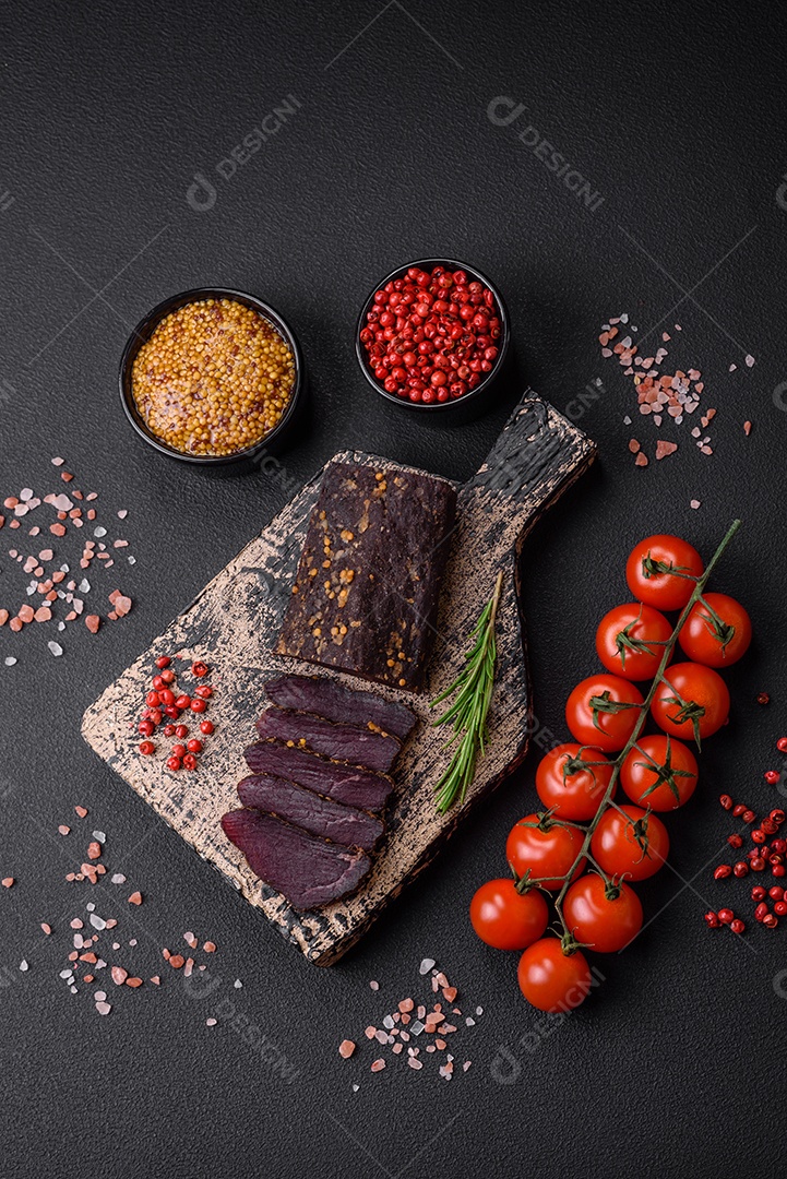 Delicioso basturma armênio defumado com especiarias e ervas cortadas em um fundo escuro de concreto