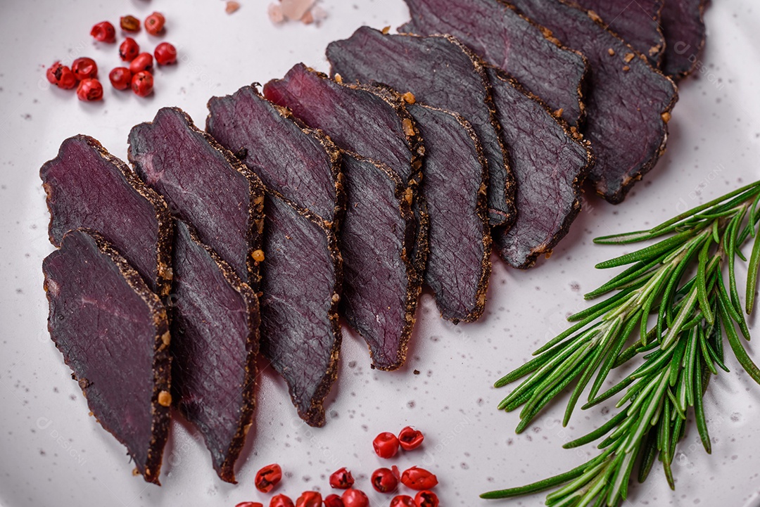 Deliciosa carne seca defumada ou carne seca de cavalo com especiarias e sal sobre um fundo escuro de concreto