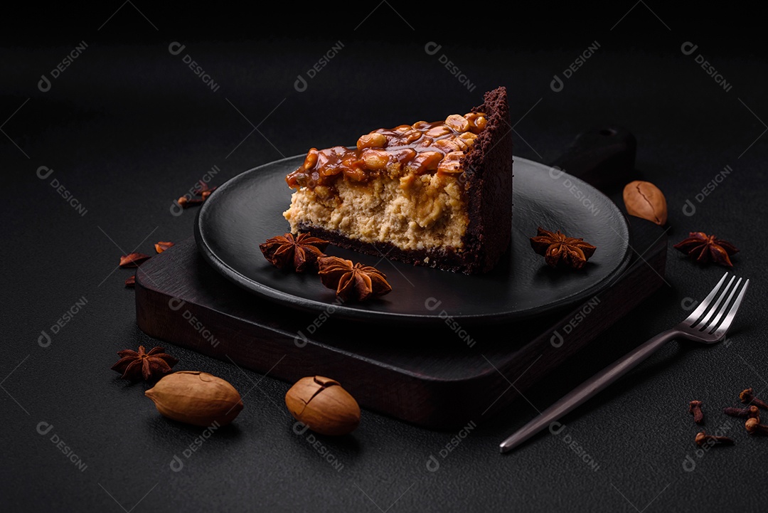 Delicioso bolo de queijo fresco ou snickers com creme e nozes em uma placa cerâmica sobre um fundo escuro de concreto