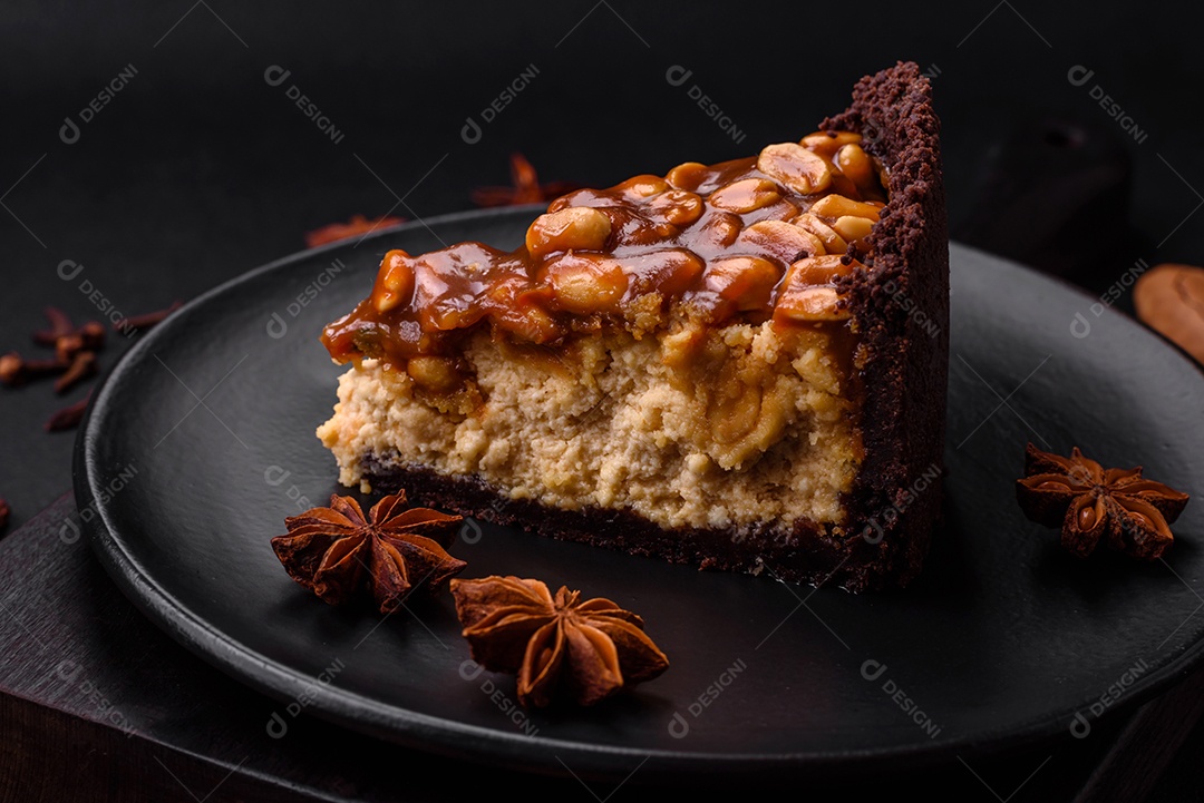 Delicioso bolo de queijo fresco ou snickers com creme e nozes em uma placa cerâmica sobre um fundo escuro de concreto