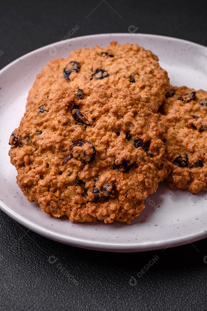 Deliciosos biscoitos de aveia assados ​​em um fundo escuro de concreto. Doces no café da manhã