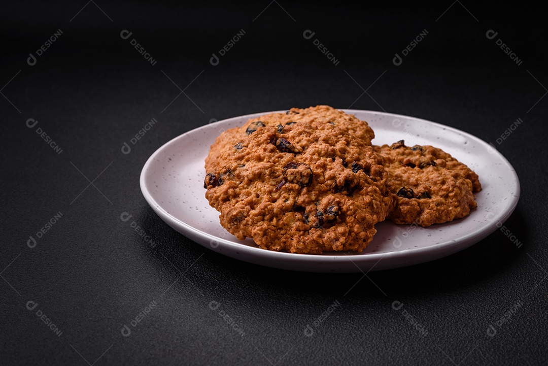 Deliciosos biscoitos de aveia assados ​​em um fundo escuro de concreto. Doces no café da manhã