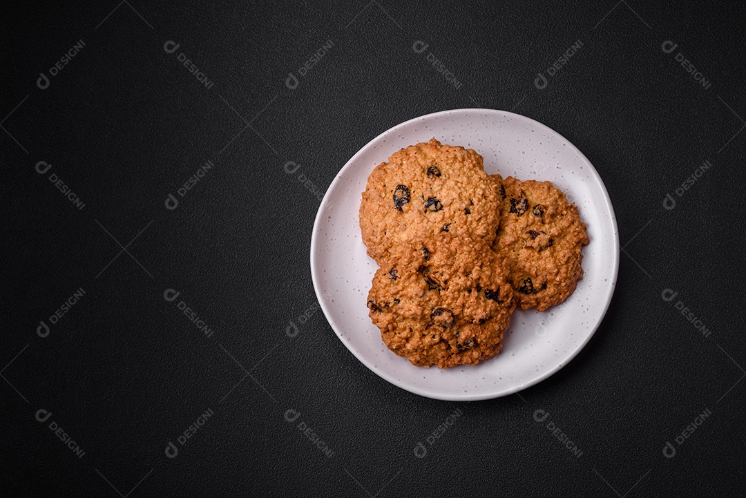 Deliciosos biscoitos de aveia assados ​​em um fundo escuro de concreto. Doces no café da manhã