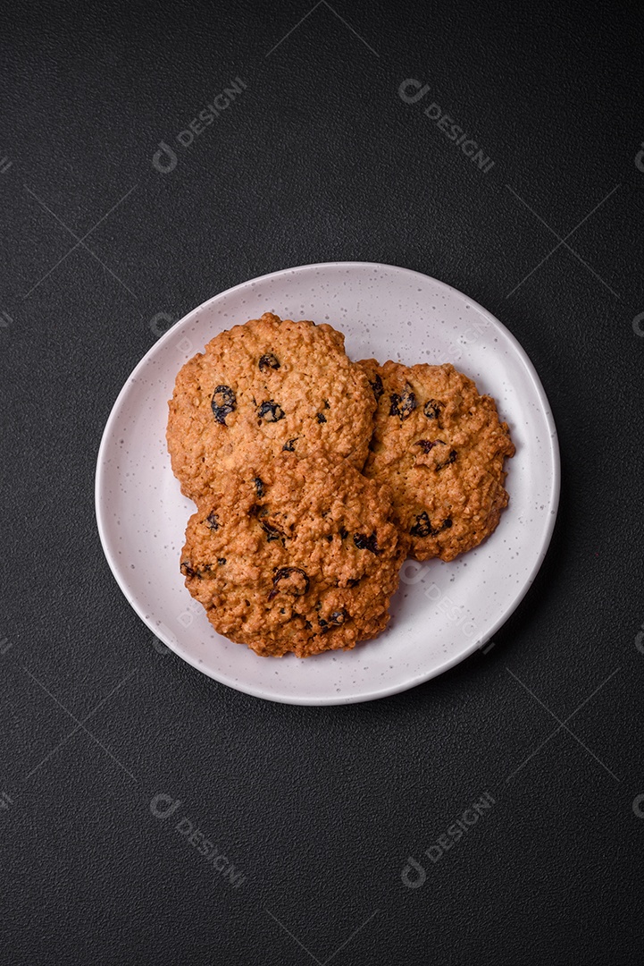 Deliciosos biscoitos de aveia assados ​​em um fundo escuro de concreto. Doces no café da manhã