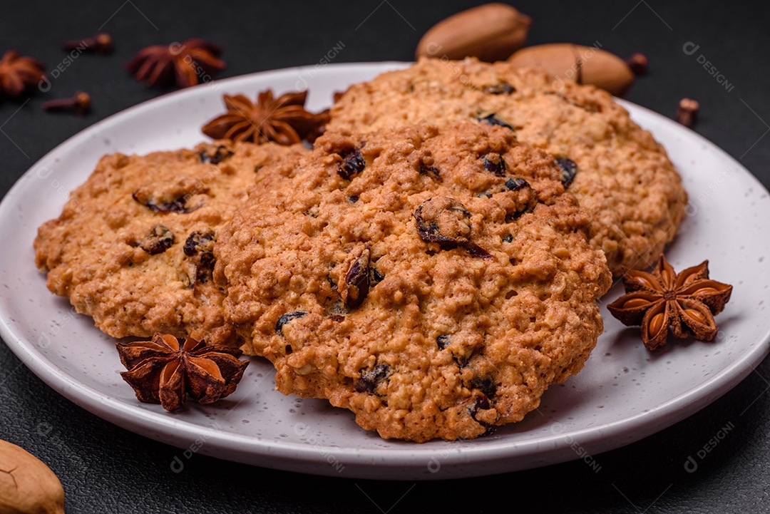 Deliciosos biscoitos de aveia assados ​​em um fundo escuro de concreto. Doces no café da manhã