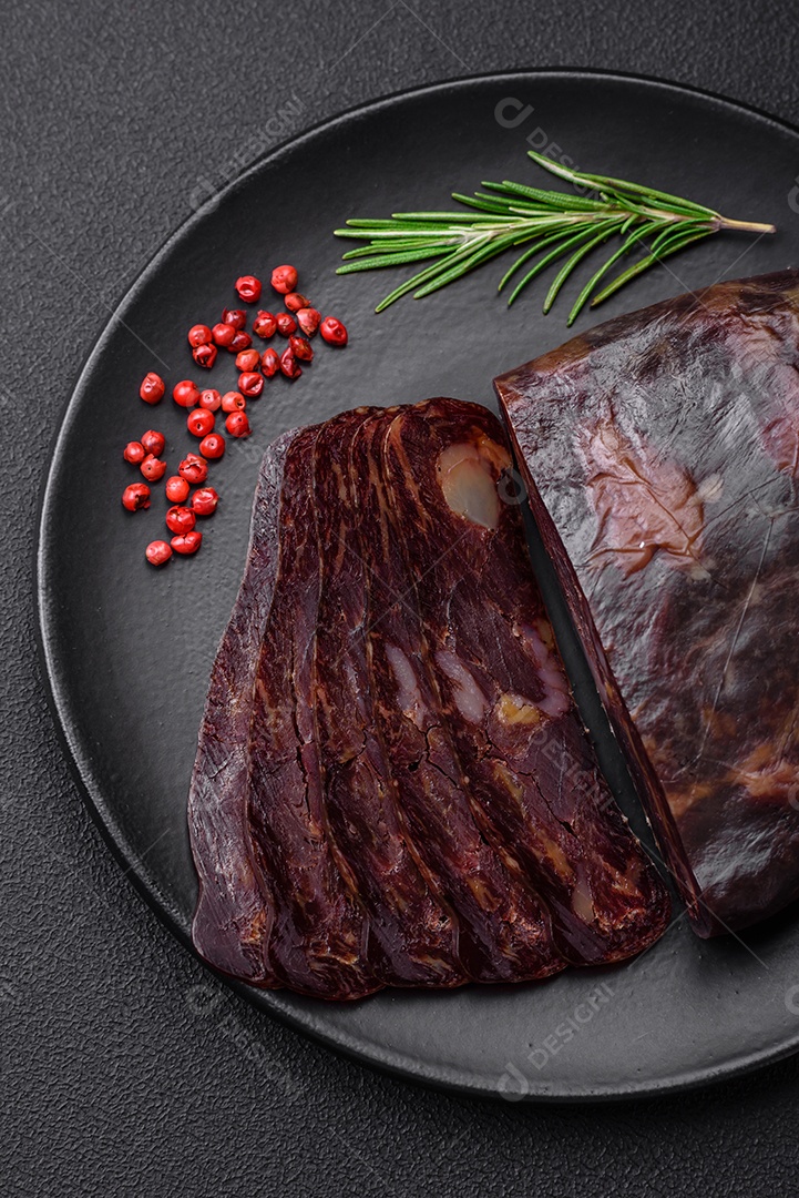 Deliciosa salsicha de carne de cavalo mahan fumada ou curada com especiarias e ervas sobre um fundo escuro de concreto