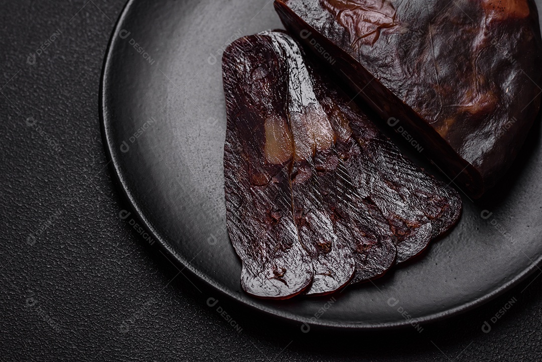 Deliciosa salsicha de carne de cavalo mahan fumada ou curada com especiarias e ervas sobre um fundo escuro de concreto