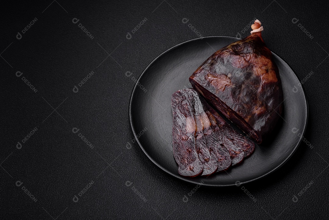 Deliciosa salsicha de carne de cavalo mahan fumada ou curada com especiarias e ervas sobre um fundo escuro de concreto