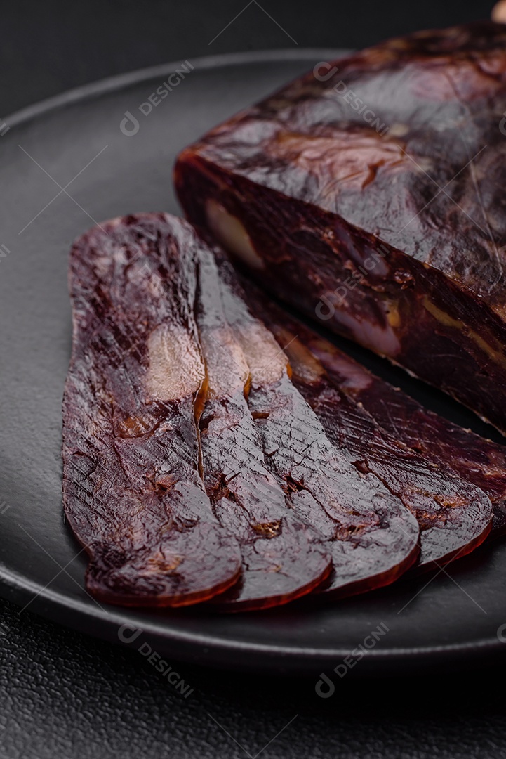 Deliciosa salsicha de carne de cavalo mahan fumada ou curada com especiarias e ervas sobre um fundo escuro de concreto