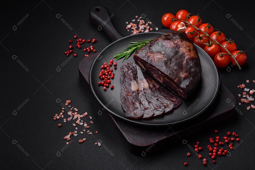 Deliciosa salsicha de carne de cavalo mahan fumada ou curada com especiarias e ervas sobre um fundo escuro de concreto