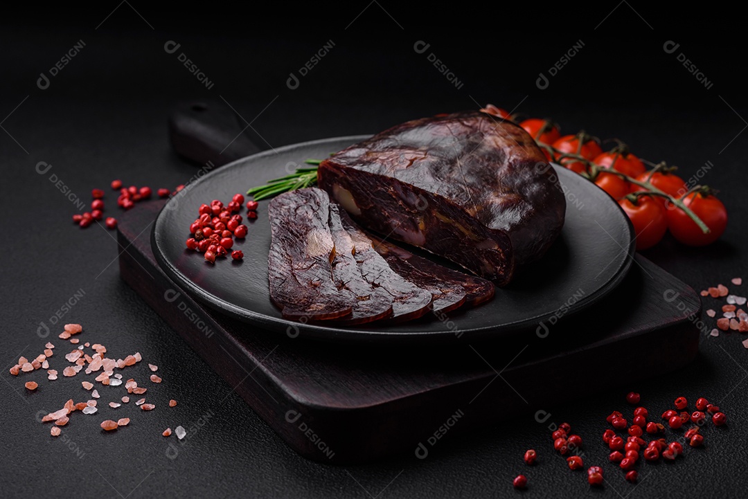 Deliciosa salsicha de carne de cavalo mahan fumada ou curada com especiarias e ervas sobre um fundo escuro de concreto